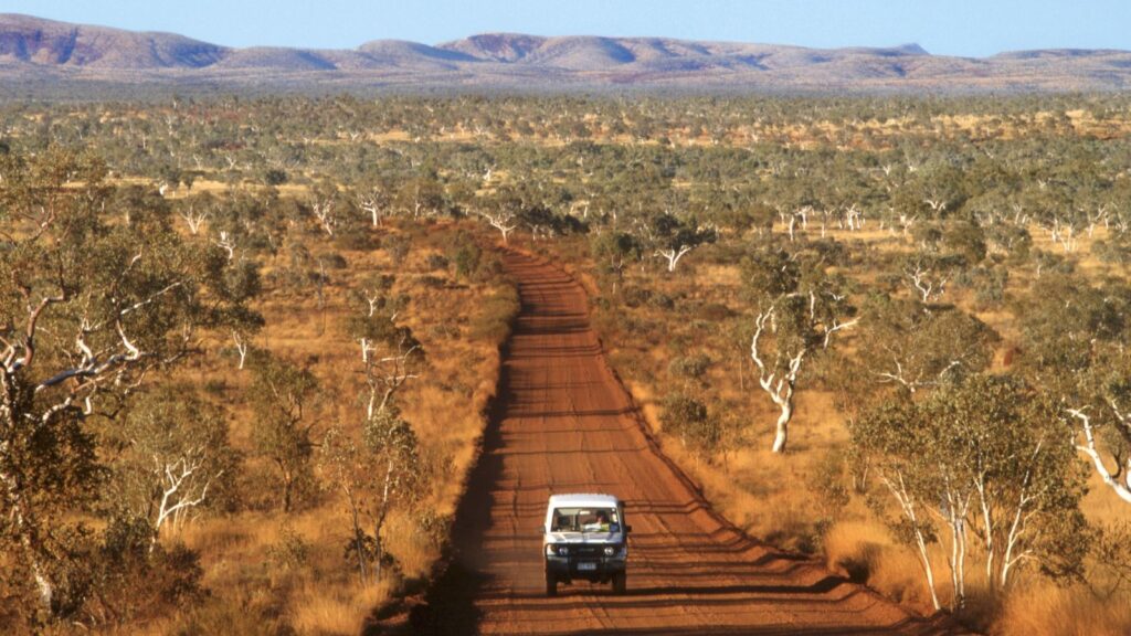SUV driving on a dirt road through the Kimberly, Australian Outback.