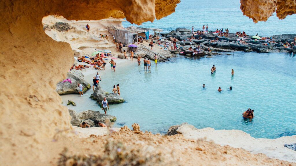 People swimming in tide pools near cliffs in Spain.