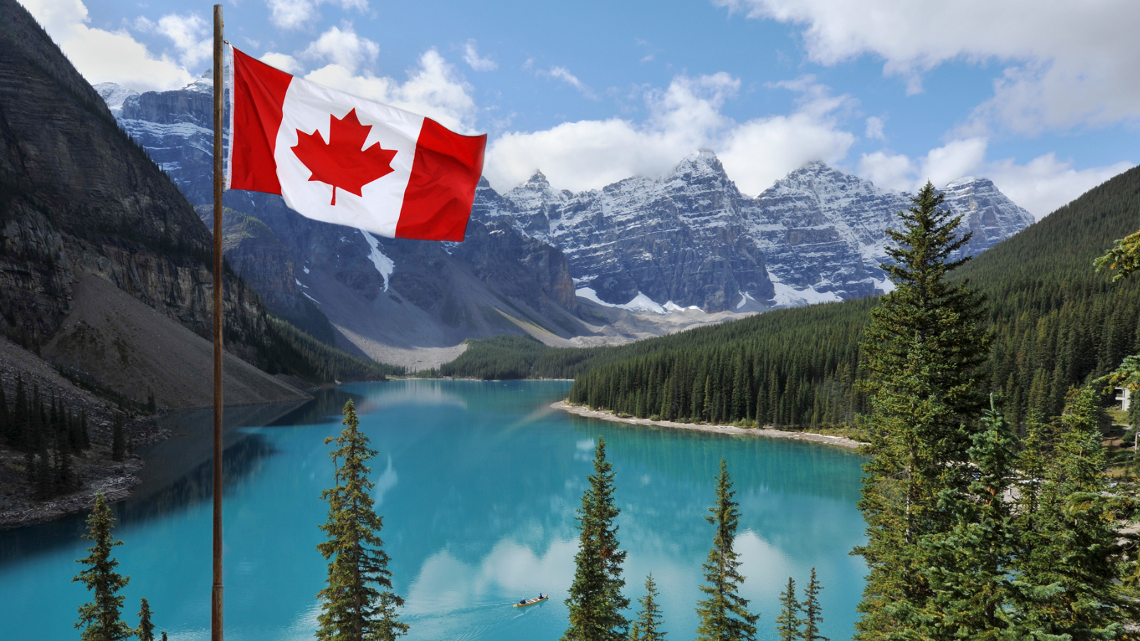 Canadian national flag set against the Rocky Mountains of Banff National Park, Canada.